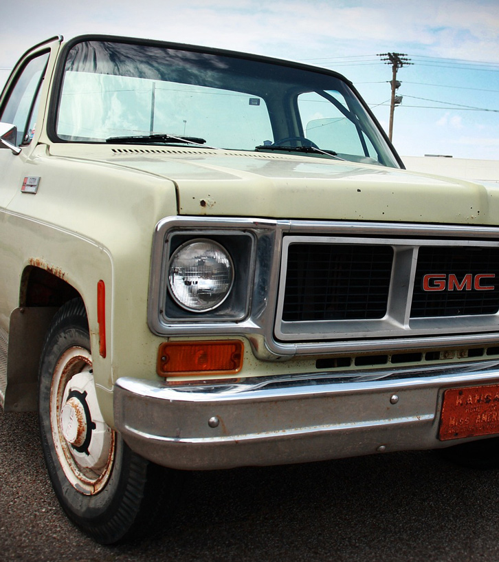 An older cream-colored GMC pickup truck.